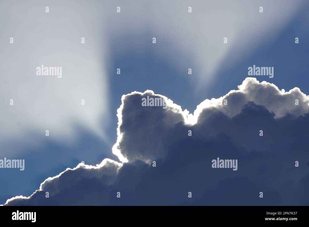 Closeup di raggi di sole che brillano sopra le nuvole soffici su un cielo blu sull'isola tropicale di la Réunion, Francia Foto Stock
