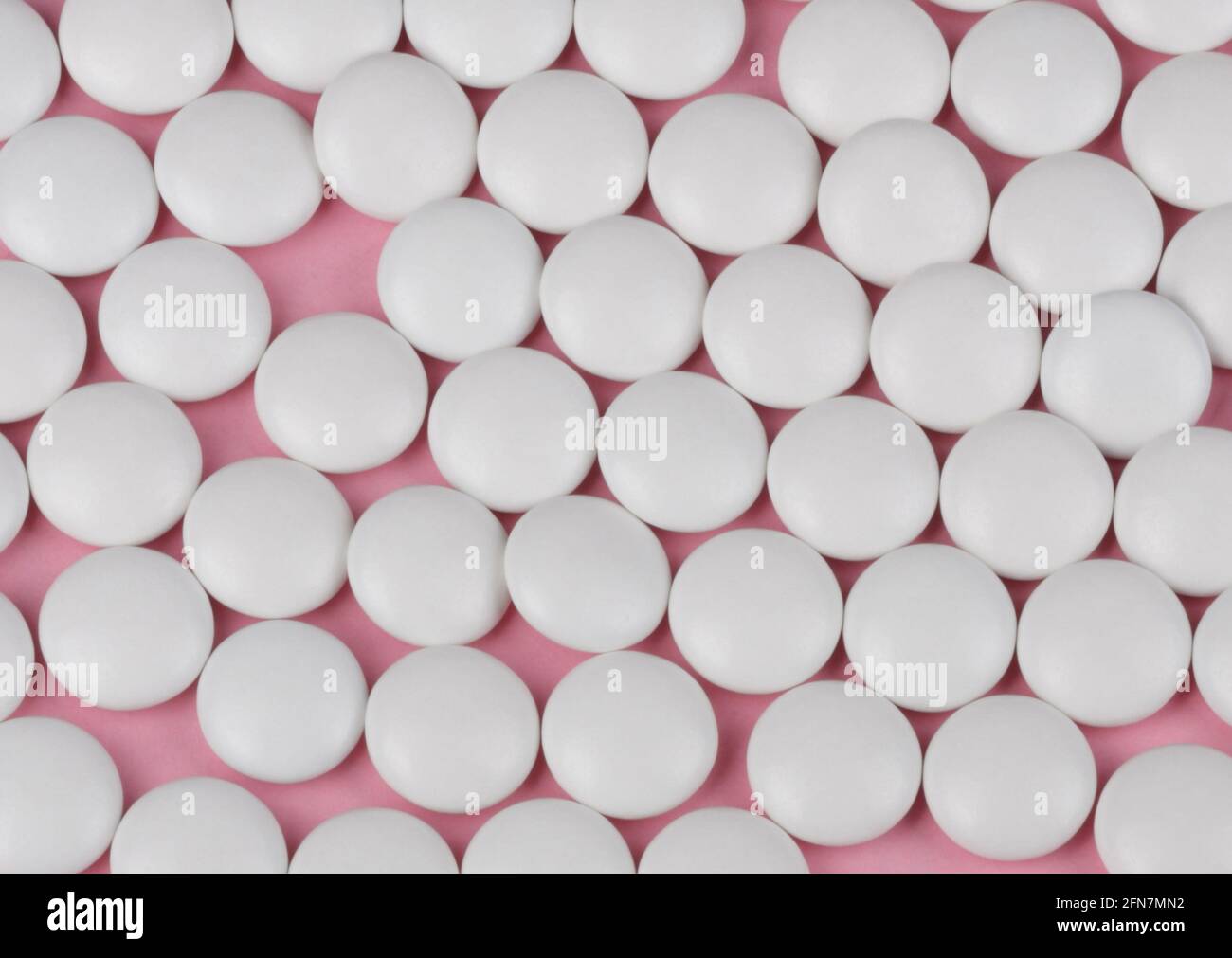 Pillola bianco su sfondo rosa Foto Stock