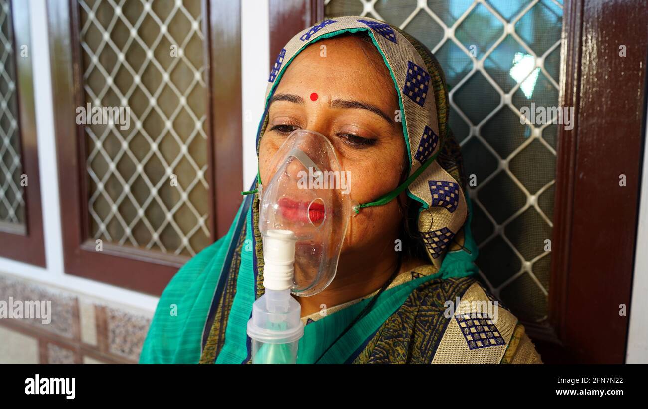 03 maggio 2021 - Reengus, Sikar, India. Donna che soffre di malattia di Covid 19. Giovane donna ricoverata in ospedale e inalando ossigeno di emergenza con la canula Foto Stock