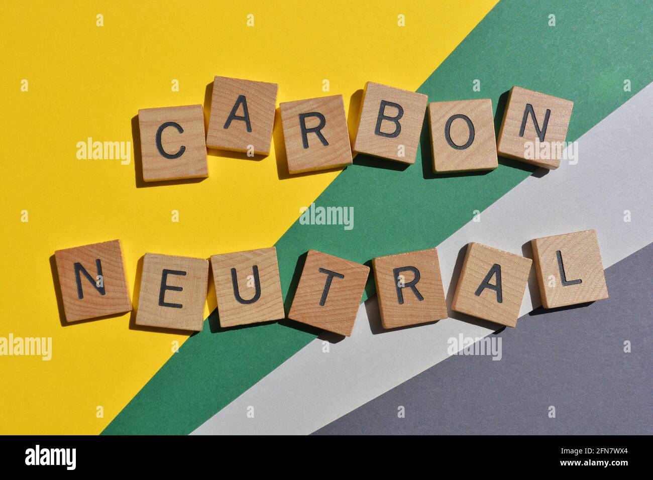 Carbon Neutral, parole in lettere alfabetiche in legno isolate su sfondo colorato. Foto Stock