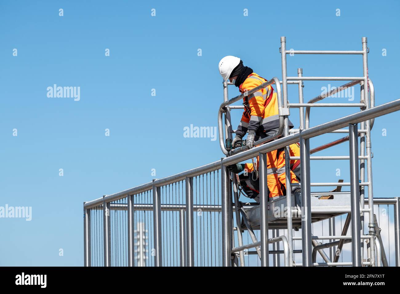 Lavoratori che lavorano su ponteggi Foto Stock