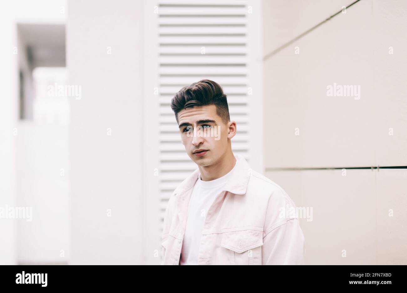 elegante giovane uomo con giacca bianca in stile urbano Foto Stock