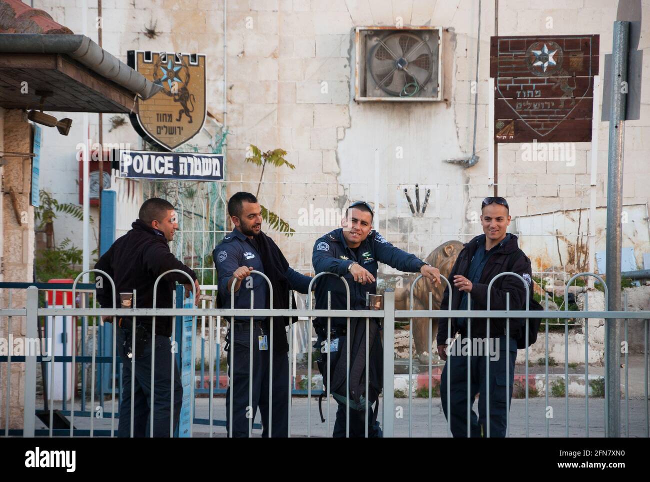 Gerusalemme, Israele. Quattro agenti di polizia hanno pausa caffè presso la corte della stazione di polizia. In caso di emergenza, la polizia può essere raggiunta chiamando il numero 100. Foto Stock