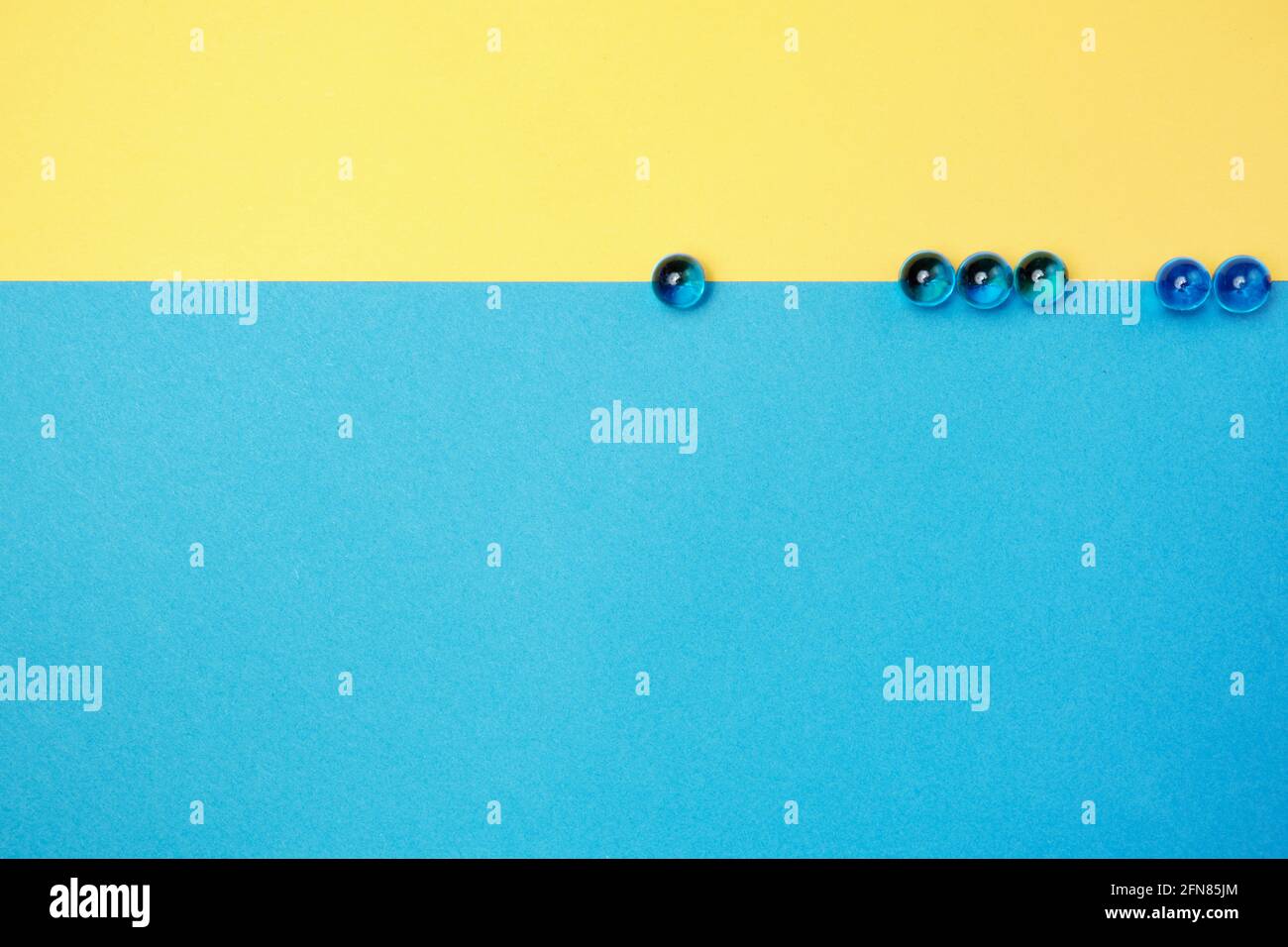 Perline di vetro su sfondo di carta colorato. Posiziona per il testo Foto Stock