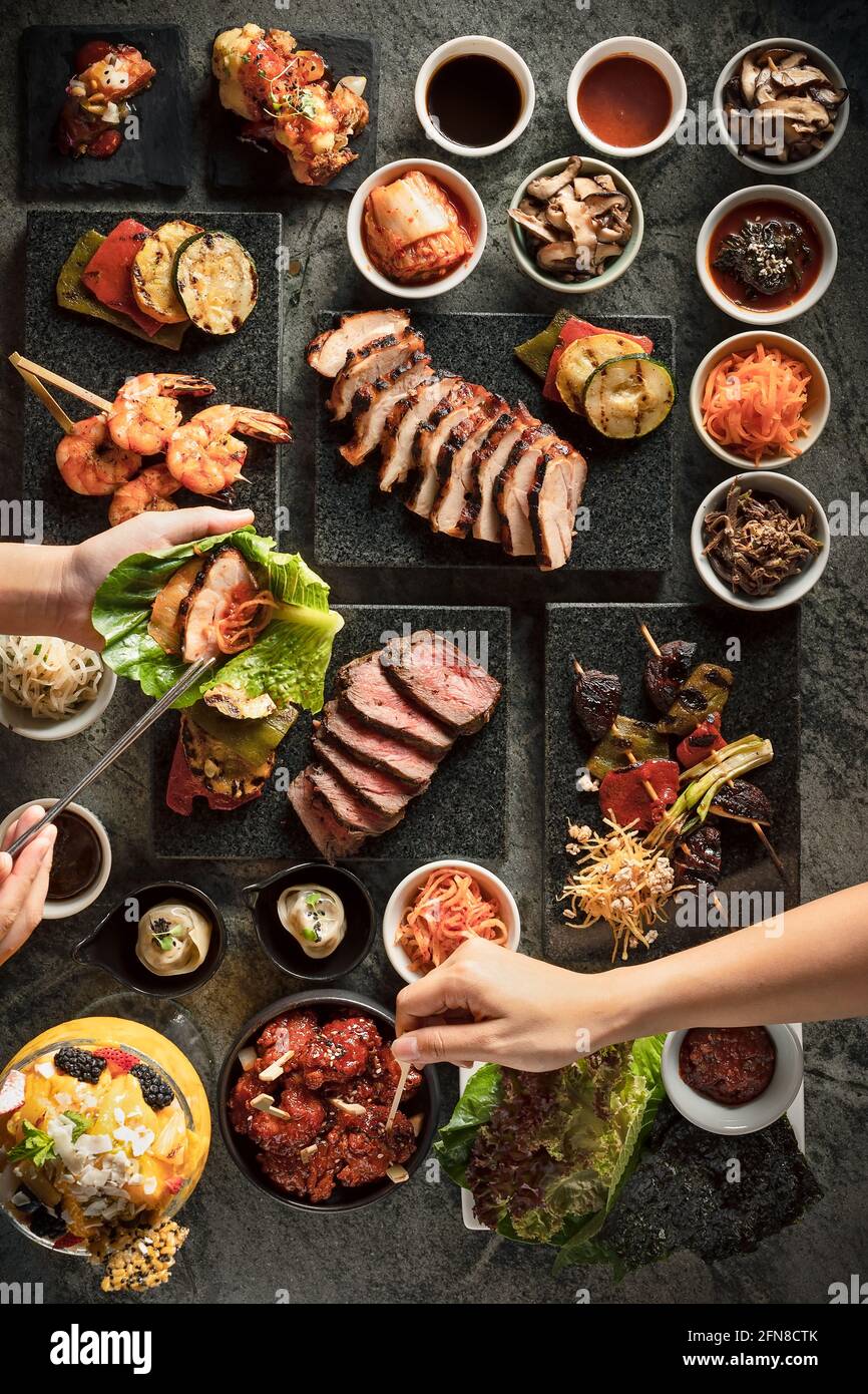 Piatto di persone che vi preparano barbecue coreani morsi Foto Stock