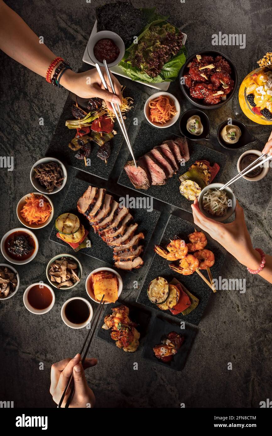 Piatto di persone che vi preparano barbecue coreani morsi Foto Stock