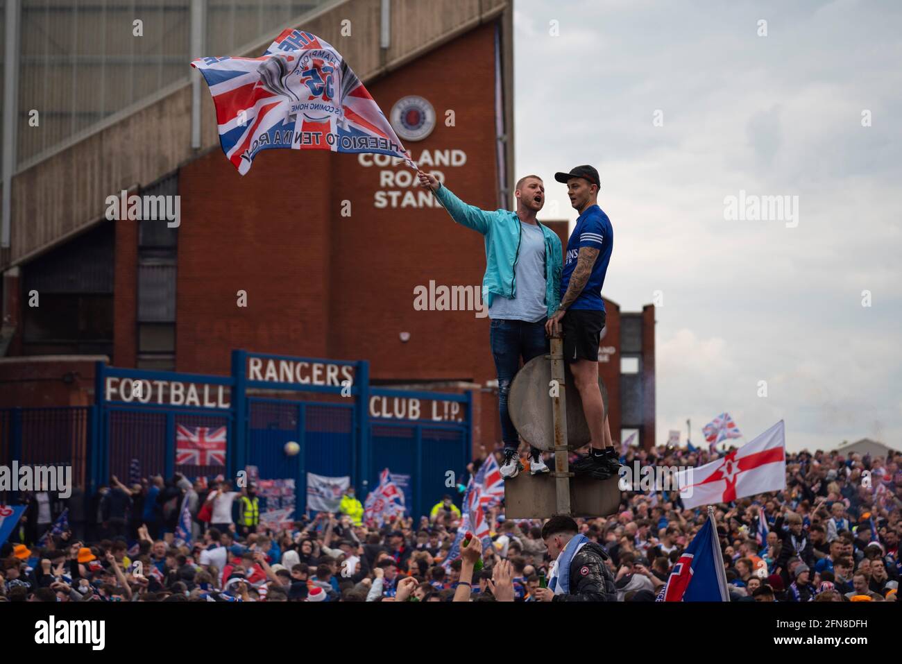 Glasgow, Scozia, Regno Unito. 15 maggio 2021. Migliaia di tifosi e tifosi della squadra di calcio dei Rangers scendono sull'Ibrox Park di Glasgow per celebrare la vittoria del campionato scozzese di premiership per la 55a volta e la prima volta per 10 anni. Le bombe di fumo e i fuochi d'artificio sono lasciati fuori dai ventilatori strettamente controllati dalla polizia lontano dalle entrate dello stadio.Iain Masterton/Alamy Live News Foto Stock