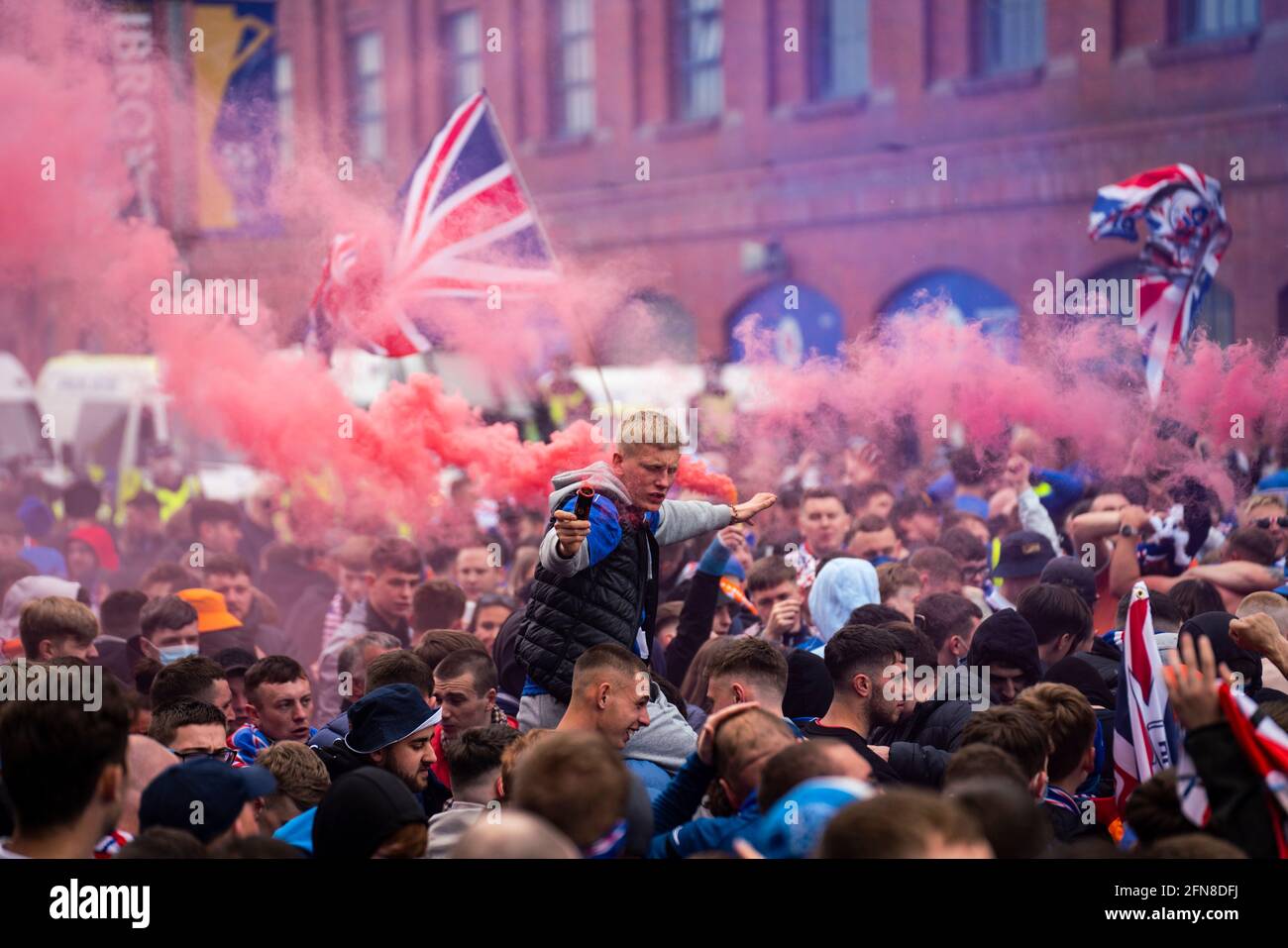 Glasgow, Scozia, Regno Unito. 15 maggio 2021. Migliaia di tifosi e tifosi della squadra di calcio dei Rangers scendono sull'Ibrox Park di Glasgow per celebrare la vittoria del campionato scozzese di premiership per la 55a volta e la prima volta per 10 anni. Le bombe di fumo e i fuochi d'artificio sono lasciati fuori dai ventilatori strettamente controllati dalla polizia lontano dalle entrate dello stadio.Iain Masterton/Alamy Live News Foto Stock