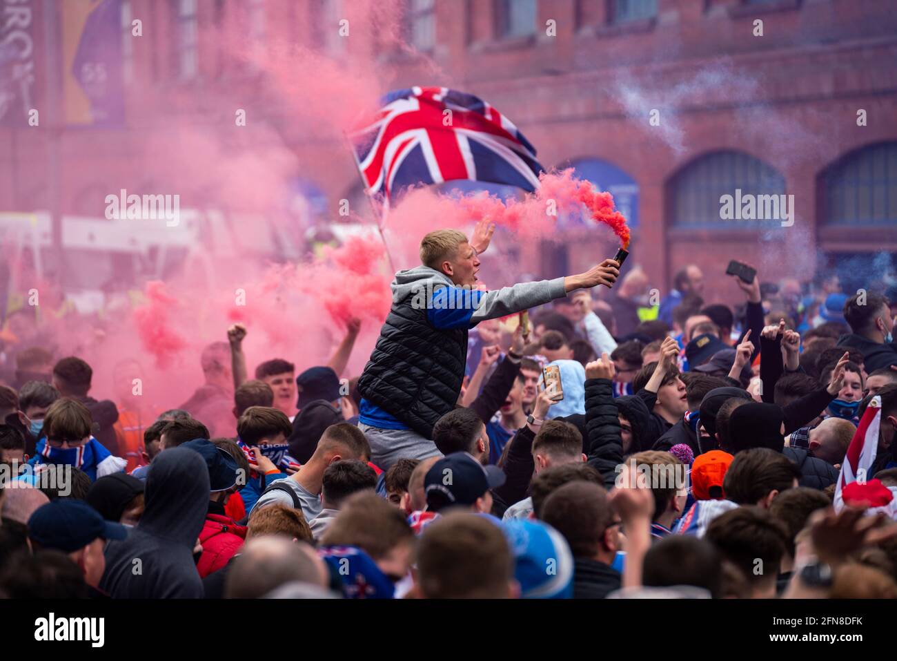 Glasgow, Scozia, Regno Unito. 15 maggio 2021. Migliaia di tifosi e tifosi della squadra di calcio dei Rangers scendono sull'Ibrox Park di Glasgow per celebrare la vittoria del campionato scozzese di premiership per la 55a volta e la prima volta per 10 anni. Le bombe di fumo e i fuochi d'artificio sono lasciati fuori dai ventilatori strettamente controllati dalla polizia lontano dalle entrate dello stadio.Iain Masterton/Alamy Live News Foto Stock