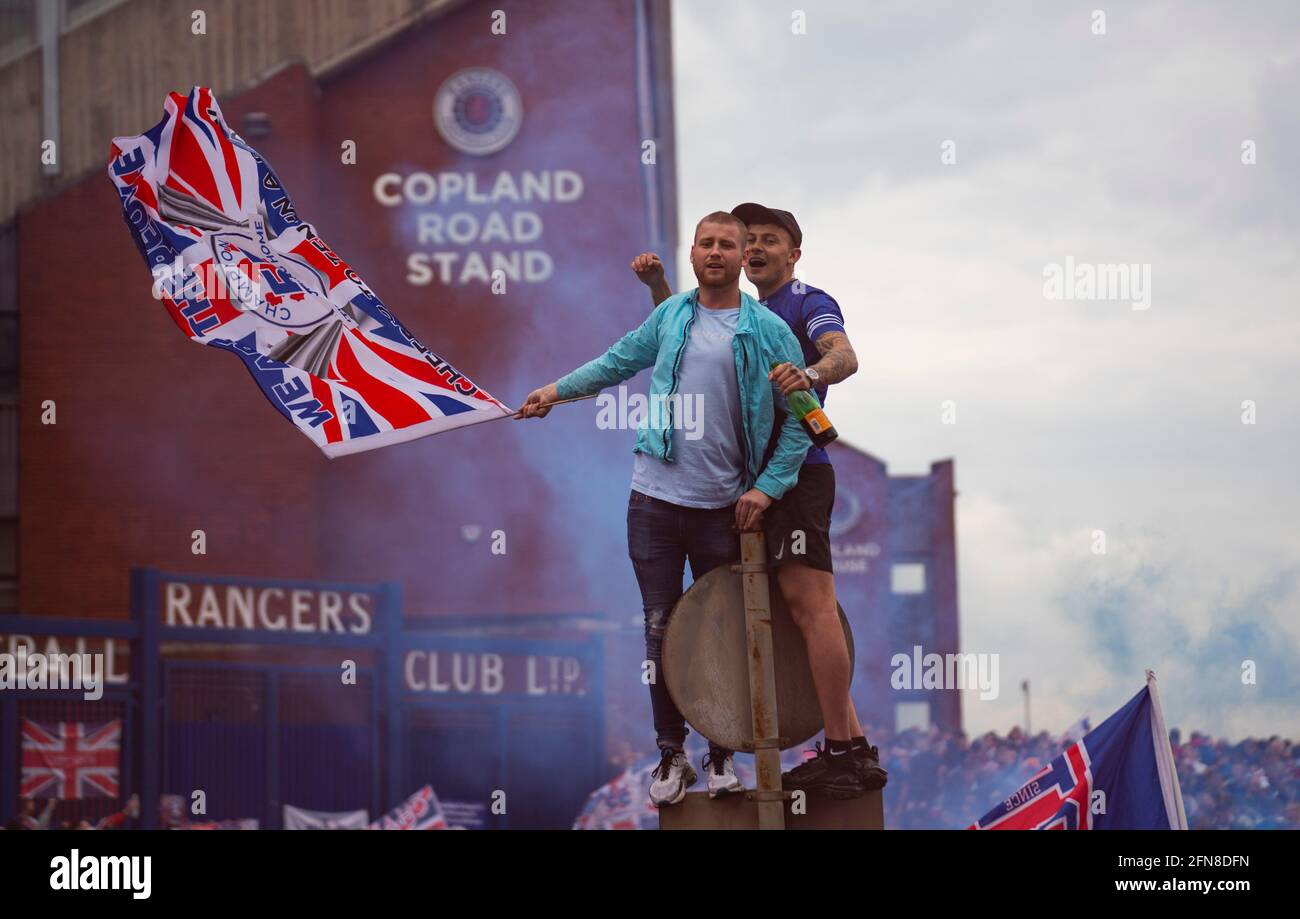 Glasgow, Scozia, Regno Unito. 15 maggio 2021. Migliaia di tifosi e tifosi della squadra di calcio dei Rangers scendono sull'Ibrox Park di Glasgow per celebrare la vittoria del campionato scozzese di premiership per la 55a volta e la prima volta per 10 anni. Le bombe di fumo e i fuochi d'artificio sono lasciati fuori dai ventilatori strettamente controllati dalla polizia lontano dalle entrate dello stadio.Iain Masterton/Alamy Live News Foto Stock