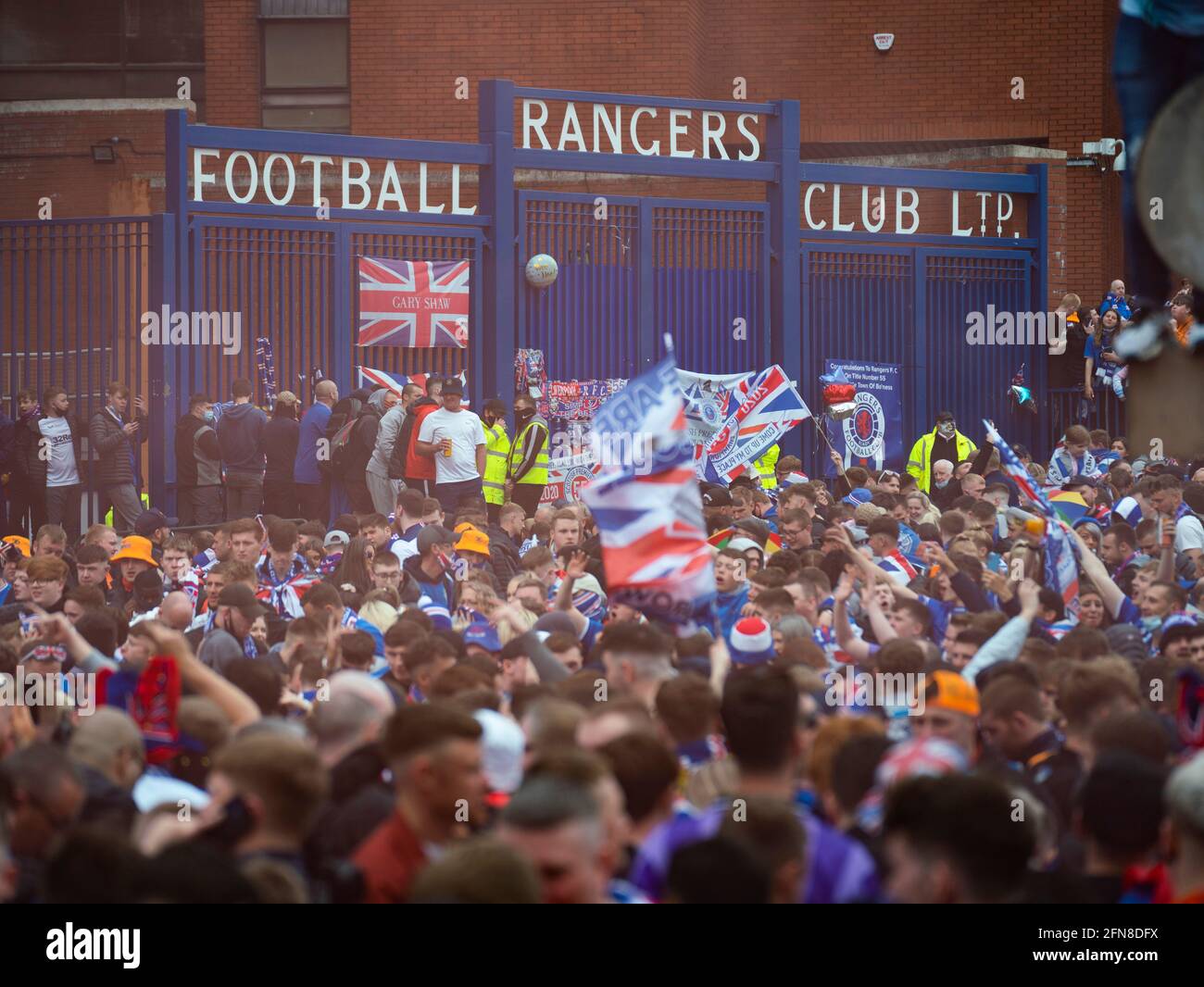 Glasgow, Scozia, Regno Unito. 15 maggio 2021. Migliaia di tifosi e tifosi della squadra di calcio dei Rangers scendono sull'Ibrox Park di Glasgow per celebrare la vittoria del campionato scozzese di premiership per la 55a volta e la prima volta per 10 anni. Le bombe di fumo e i fuochi d'artificio sono lasciati fuori dai ventilatori strettamente controllati dalla polizia lontano dalle entrate dello stadio.Iain Masterton/Alamy Live News Foto Stock