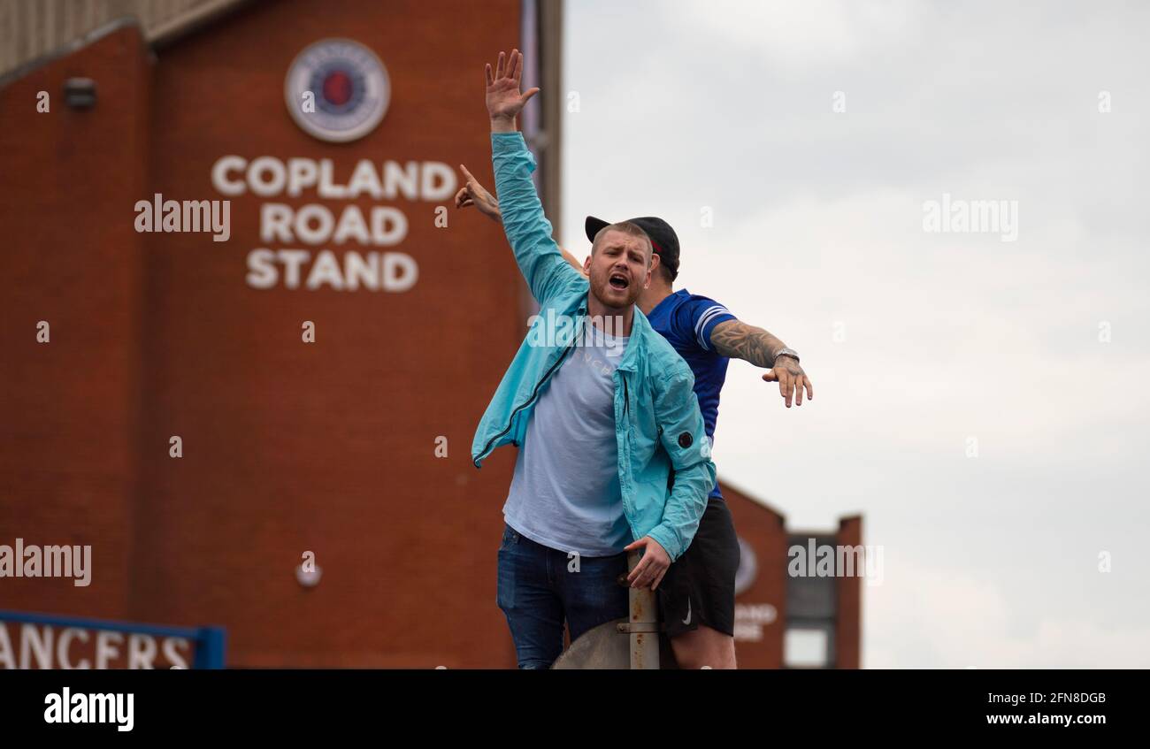 Glasgow, Scozia, Regno Unito. 15 maggio 2021. Migliaia di tifosi e tifosi della squadra di calcio dei Rangers scendono sull'Ibrox Park di Glasgow per celebrare la vittoria del campionato scozzese di premiership per la 55a volta e la prima volta per 10 anni. Le bombe di fumo e i fuochi d'artificio sono lasciati fuori dai ventilatori strettamente controllati dalla polizia lontano dalle entrate dello stadio.Iain Masterton/Alamy Live News Foto Stock
