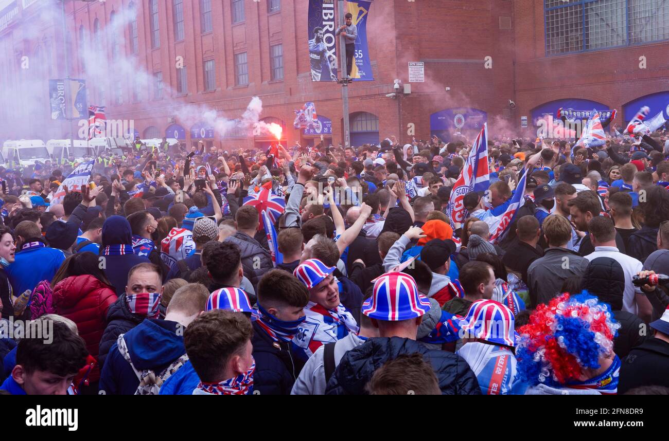 Glasgow, Scozia, Regno Unito. 15 maggio 2021. Migliaia di tifosi e tifosi della squadra di calcio dei Rangers scendono sull'Ibrox Park di Glasgow per celebrare la vittoria del campionato scozzese di premiership per la 55a volta e la prima volta per 10 anni. Le bombe di fumo e i fuochi d'artificio sono lasciati fuori dai ventilatori strettamente controllati dalla polizia lontano dalle entrate dello stadio.Iain Masterton/Alamy Live News Foto Stock
