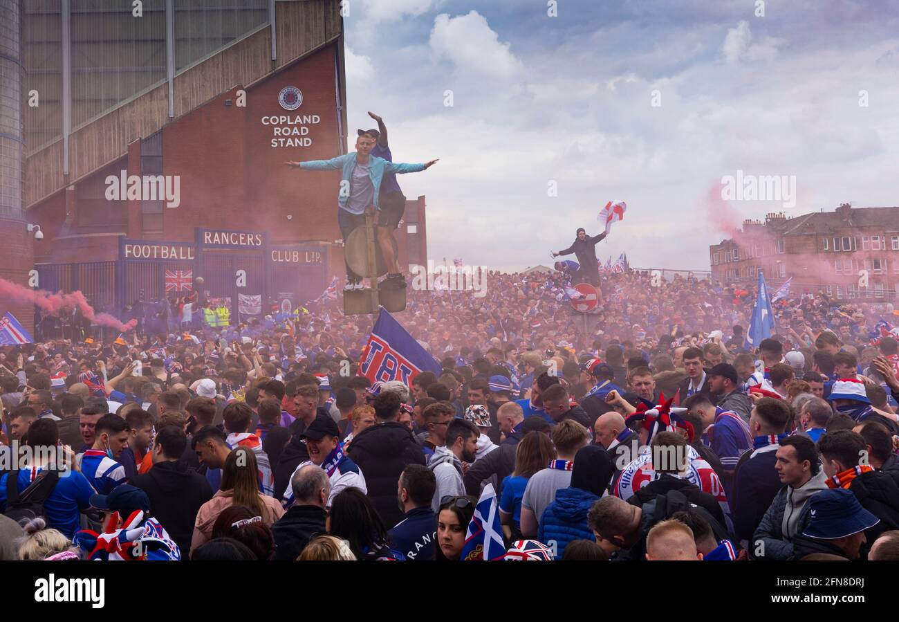 Glasgow, Scozia, Regno Unito. 15 maggio 2021. Migliaia di tifosi e tifosi della squadra di calcio dei Rangers scendono sull'Ibrox Park di Glasgow per celebrare la vittoria del campionato scozzese di premiership per la 55a volta e la prima volta per 10 anni. Le bombe di fumo e i fuochi d'artificio sono lasciati fuori dai ventilatori strettamente controllati dalla polizia lontano dalle entrate dello stadio.Iain Masterton/Alamy Live News Foto Stock