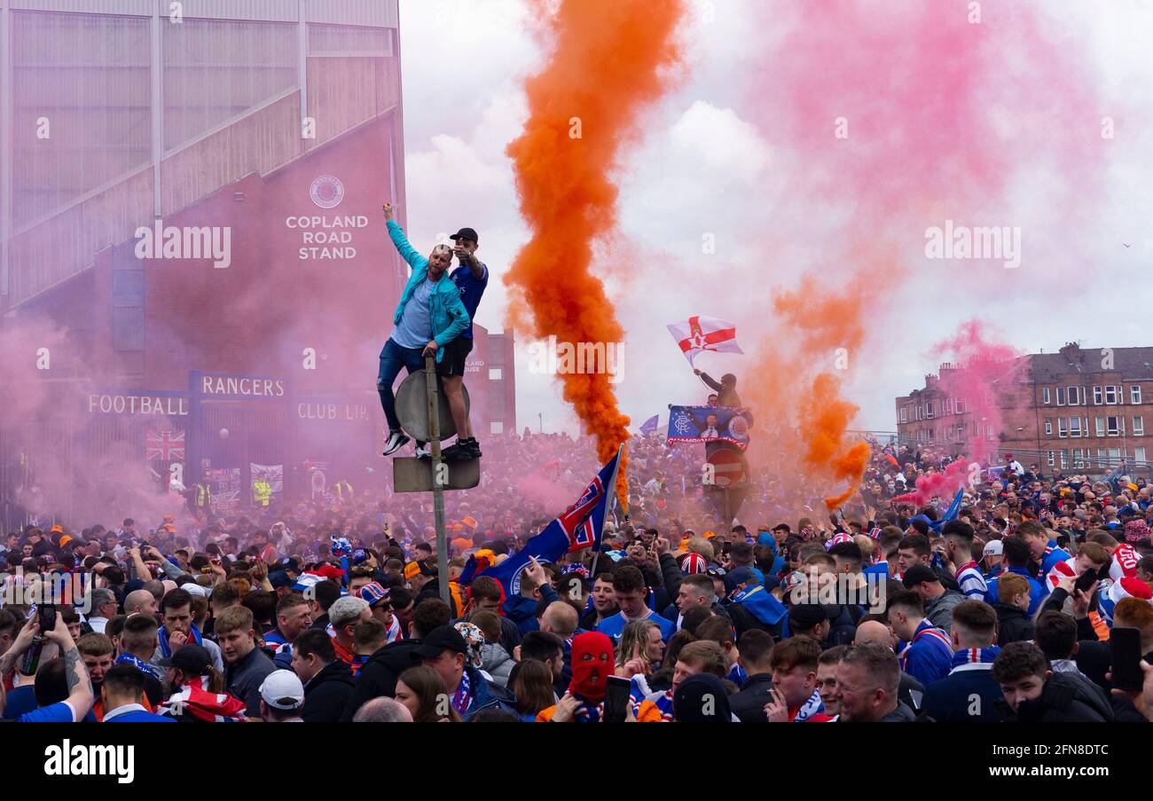 Glasgow, Scozia, Regno Unito. 15 maggio 2021. Migliaia di tifosi e tifosi della squadra di calcio dei Rangers scendono sull'Ibrox Park di Glasgow per celebrare la vittoria del campionato scozzese di premiership per la 55a volta e la prima volta per 10 anni. Le bombe di fumo e i fuochi d'artificio sono lasciati fuori dai ventilatori strettamente controllati dalla polizia lontano dalle entrate dello stadio.Iain Masterton/Alamy Live News Foto Stock