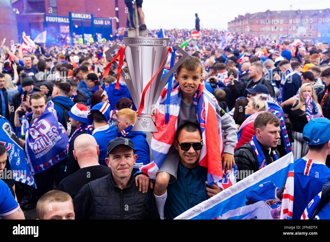 Glasgow, Scozia, Regno Unito. 15 maggio 2021. Migliaia di tifosi e tifosi della squadra di calcio dei Rangers scendono sull'Ibrox Park di Glasgow per celebrare la vittoria del campionato scozzese di premiership per la 55a volta e la prima volta per 10 anni. Le bombe di fumo e i fuochi d'artificio sono lasciati fuori dai ventilatori strettamente controllati dalla polizia lontano dalle entrate dello stadio.Iain Masterton/Alamy Live News Foto Stock