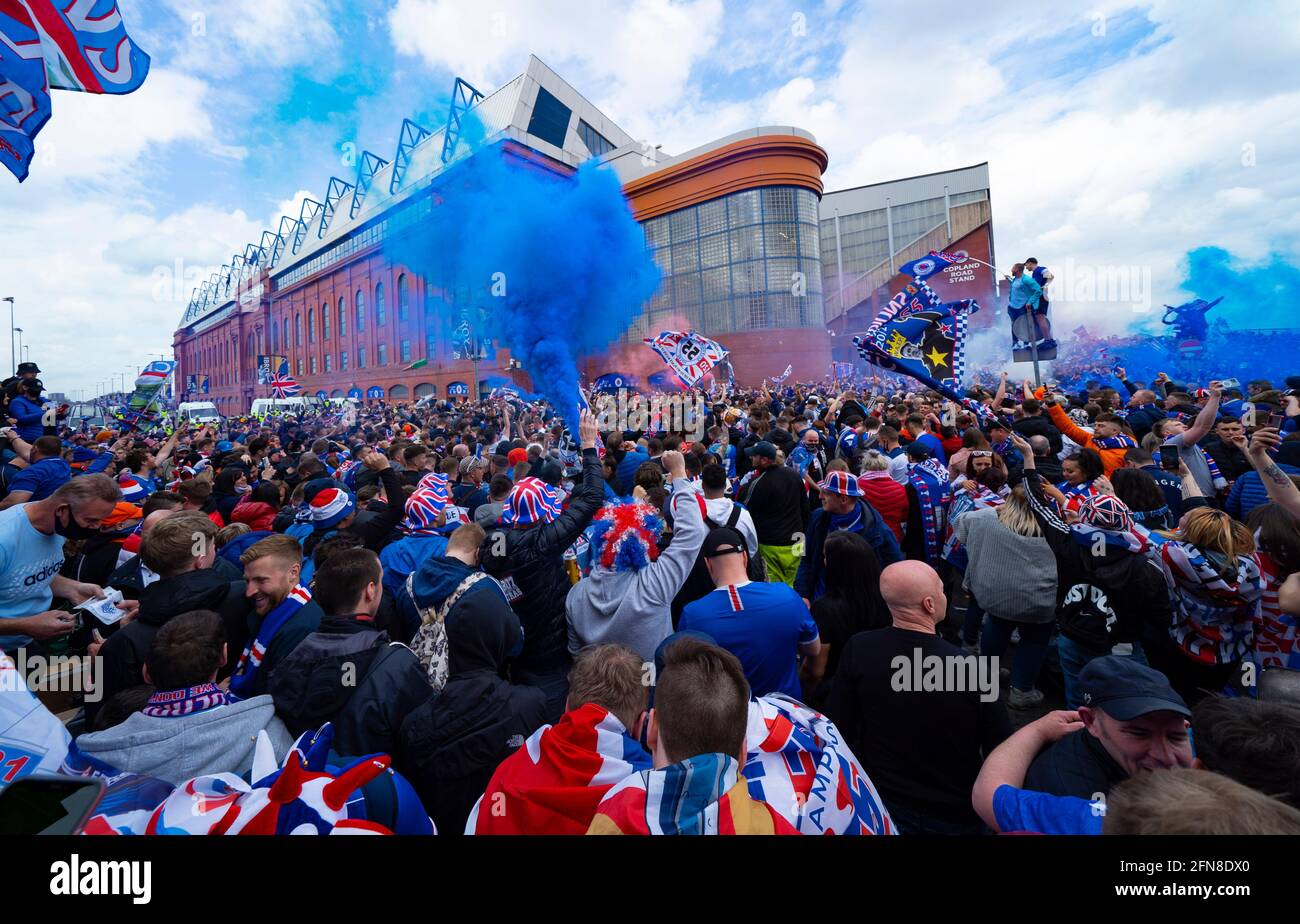 Glasgow, Scozia, Regno Unito. 15 maggio 2021. Migliaia di tifosi e tifosi della squadra di calcio dei Rangers scendono sull'Ibrox Park di Glasgow per celebrare la vittoria del campionato scozzese di premiership per la 55a volta e la prima volta per 10 anni. Le bombe di fumo e i fuochi d'artificio sono lasciati fuori dai ventilatori strettamente controllati dalla polizia lontano dalle entrate dello stadio.Iain Masterton/Alamy Live News Foto Stock