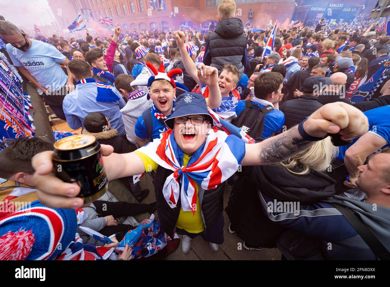 Glasgow, Scozia, Regno Unito. 15 maggio 2021. Migliaia di tifosi e tifosi della squadra di calcio dei Rangers scendono sull'Ibrox Park di Glasgow per celebrare la vittoria del campionato scozzese di premiership per la 55a volta e la prima volta per 10 anni. Le bombe di fumo e i fuochi d'artificio sono lasciati fuori dai ventilatori strettamente controllati dalla polizia lontano dalle entrate dello stadio.Iain Masterton/Alamy Live News Foto Stock