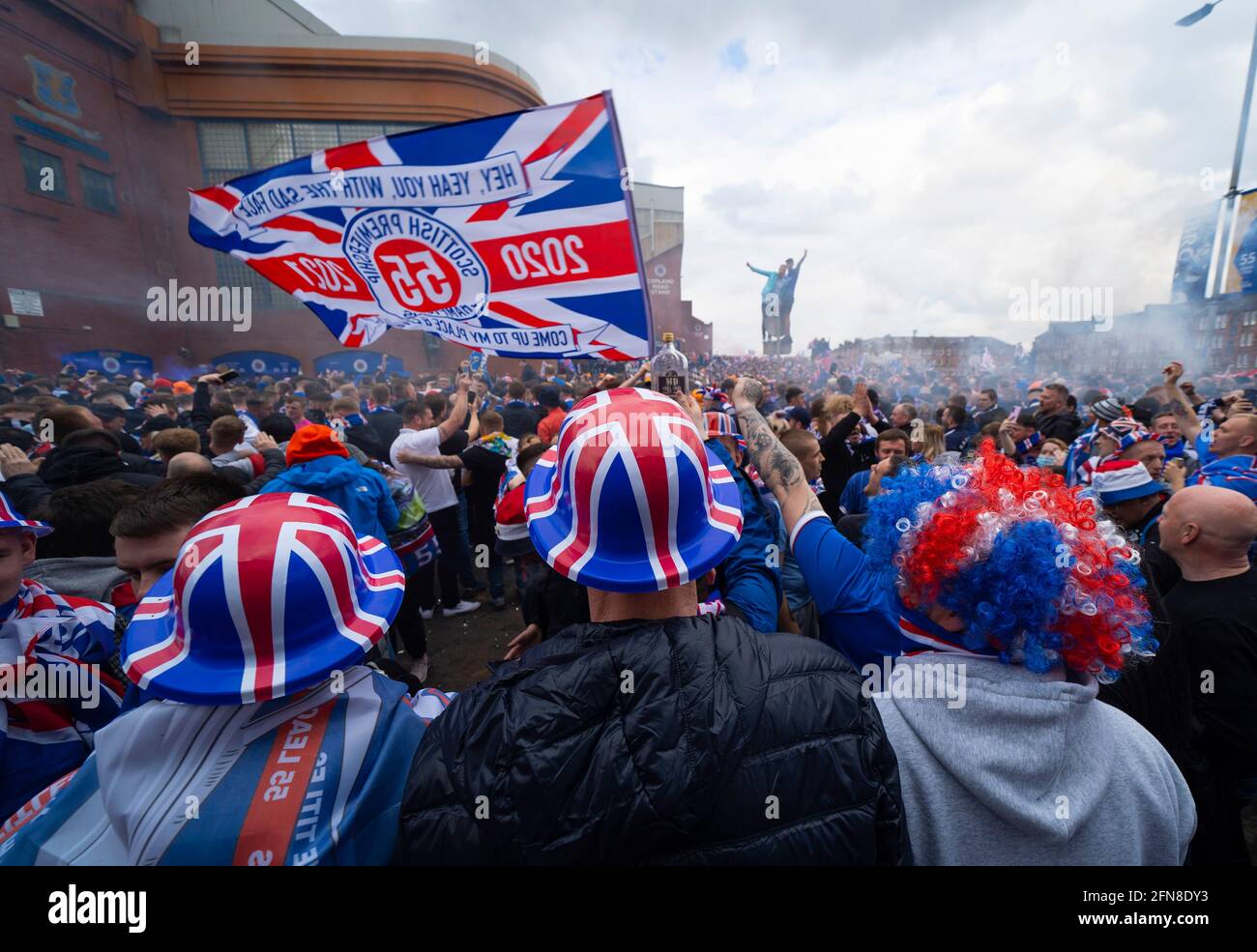 Glasgow, Scozia, Regno Unito. 15 maggio 2021. Migliaia di tifosi e tifosi della squadra di calcio dei Rangers scendono sull'Ibrox Park di Glasgow per celebrare la vittoria del campionato scozzese di premiership per la 55a volta e la prima volta per 10 anni. Le bombe di fumo e i fuochi d'artificio sono lasciati fuori dai ventilatori strettamente controllati dalla polizia lontano dalle entrate dello stadio.Iain Masterton/Alamy Live News Foto Stock