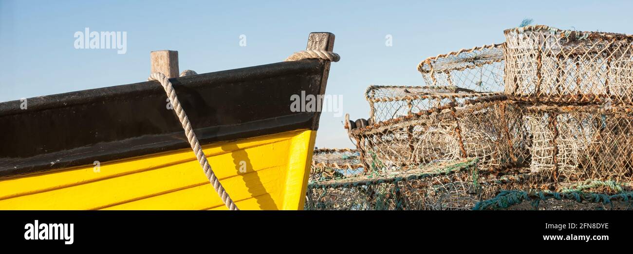 Panorama che mostra arco di piccola barca di pesca costiera in legno con granchio e pentole di aragosta Foto Stock
