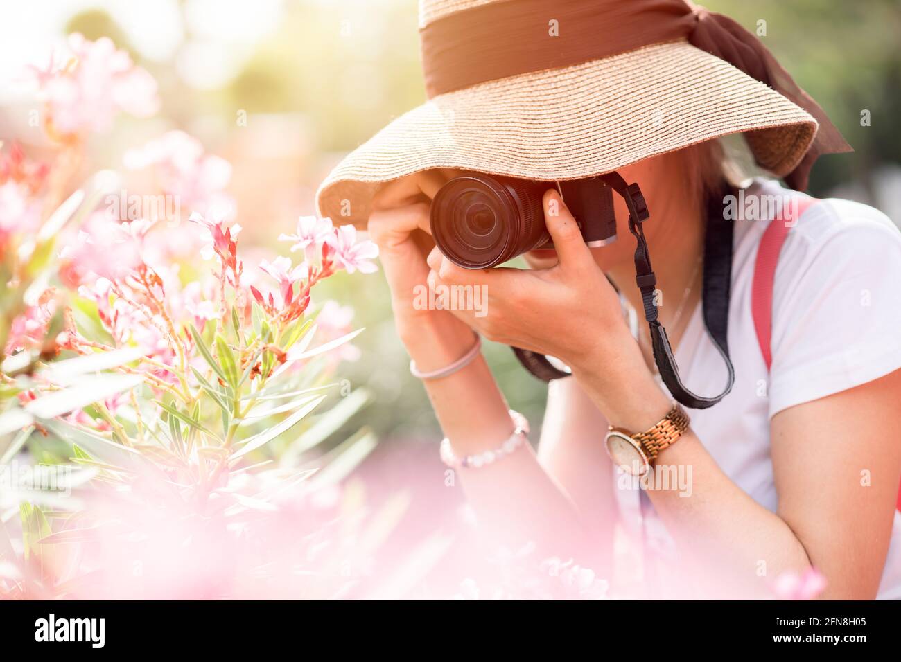 Ragazza asiatica teen turista che prende una natura viaggio foto mentre camminare con cappello e zaino Foto Stock