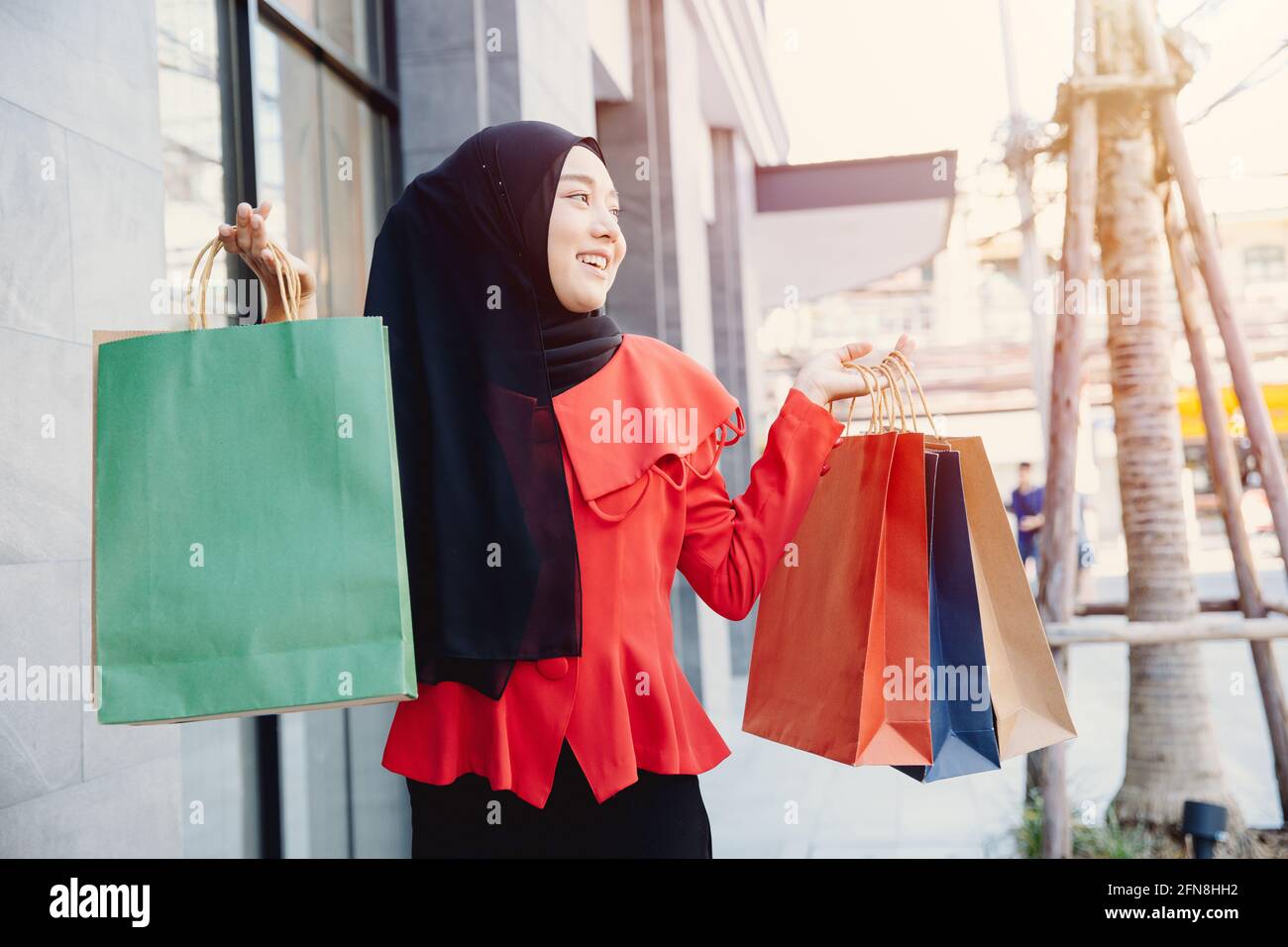 Shopping Araba musulmana adulta donna in velo hijab vestiti tenendo borse passeggiata in città strada godere di sorriso felice. Foto Stock