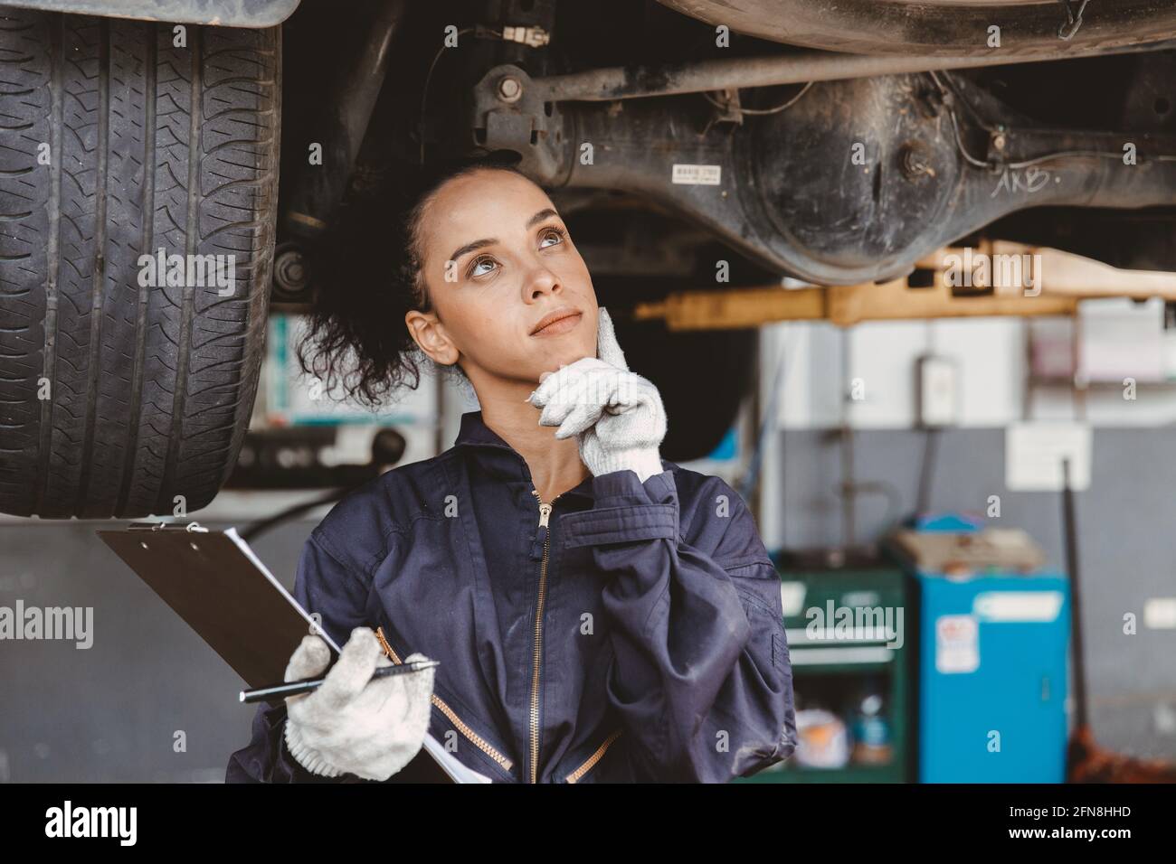Donne lavoratore meccanico pensare. Garage personale femminile pensare giorno sogno o dimenticare check list servizio auto. Foto Stock
