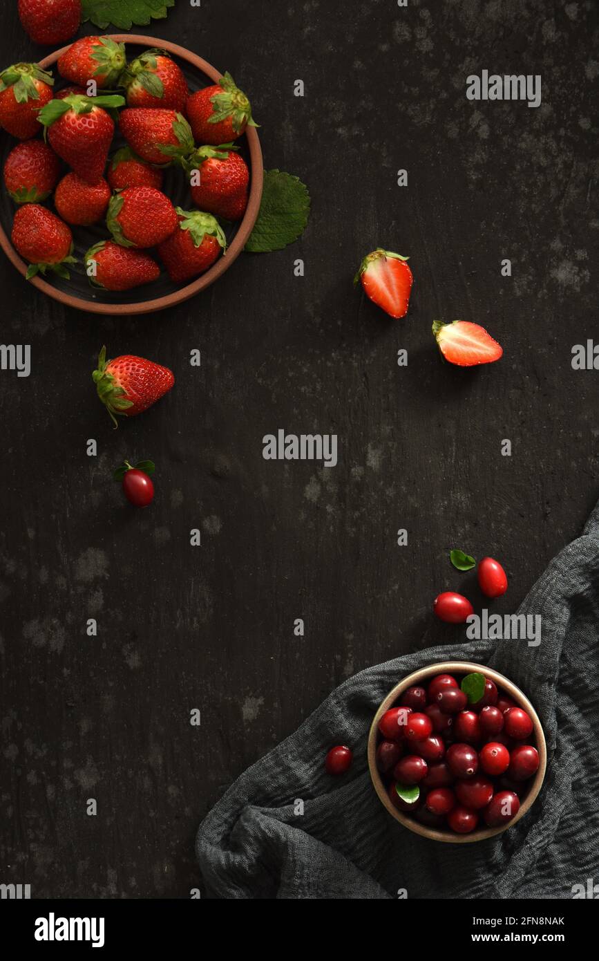 Dark Black Strawberry Cranberry in Bowl cibo piatto posare con Tagliere e panno Foto Stock