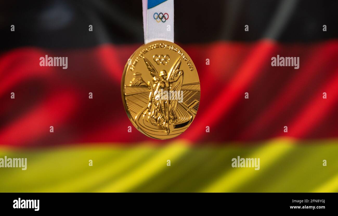 25 aprile 2021 Tokyo, Giappone. Medaglia d'oro dei XXXII Giochi Olimpici estivi 2020 a Tokyo sullo sfondo della bandiera della Germania. Foto Stock