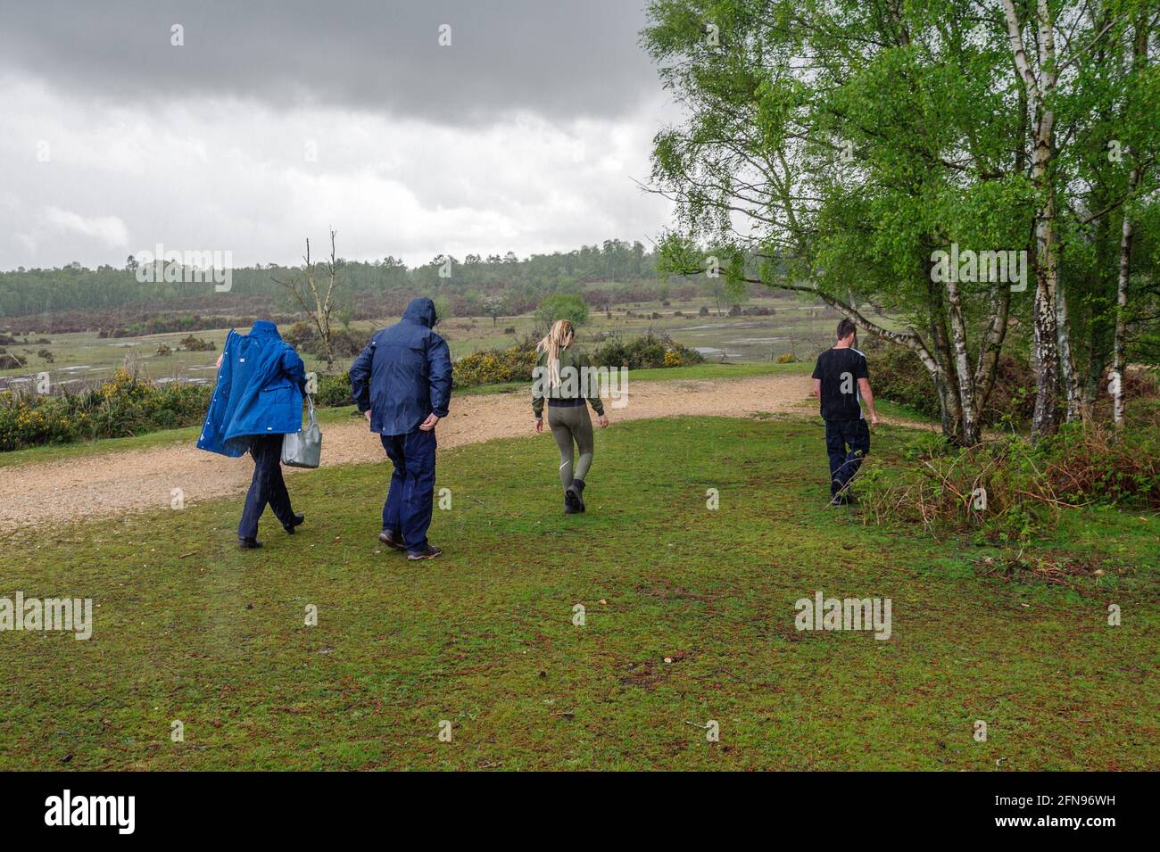 Rockford Common, Ibsley, Ringwood, New Forest, Hampshire, Regno Unito, 15 maggio 2021, Meteo: Docce a pioggia pesante. Downpoours torrenziali nel pomeriggio. La gente fuori testa a piedi per coprire sotto gli alberi. Credit: Paul Biggins/Alamy Live News Foto Stock
