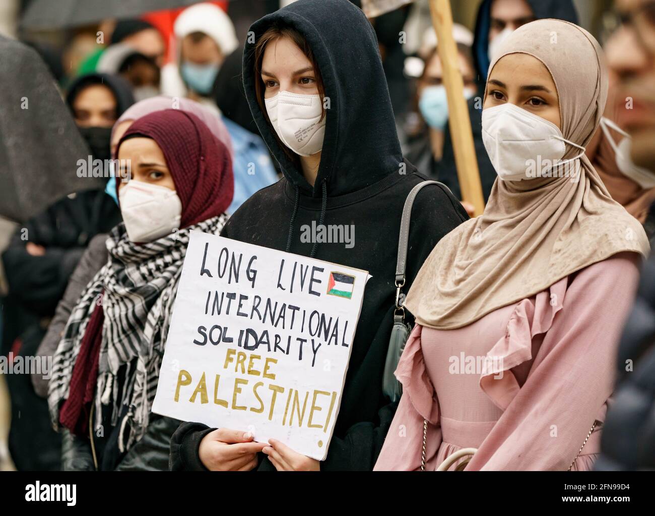 Amburgo, Germania. 15 maggio 2021. Nel corso di una manifestazione contro le azioni israeliane nell'attuale conflitto in Medio Oriente, una donna del Gänsemarkt di Amburgo ha un segno che recita "lunga vita di solidarietà internazionale - Palestina libera!". Credit: Axel Heimken/dpa/Alamy Live News Foto Stock