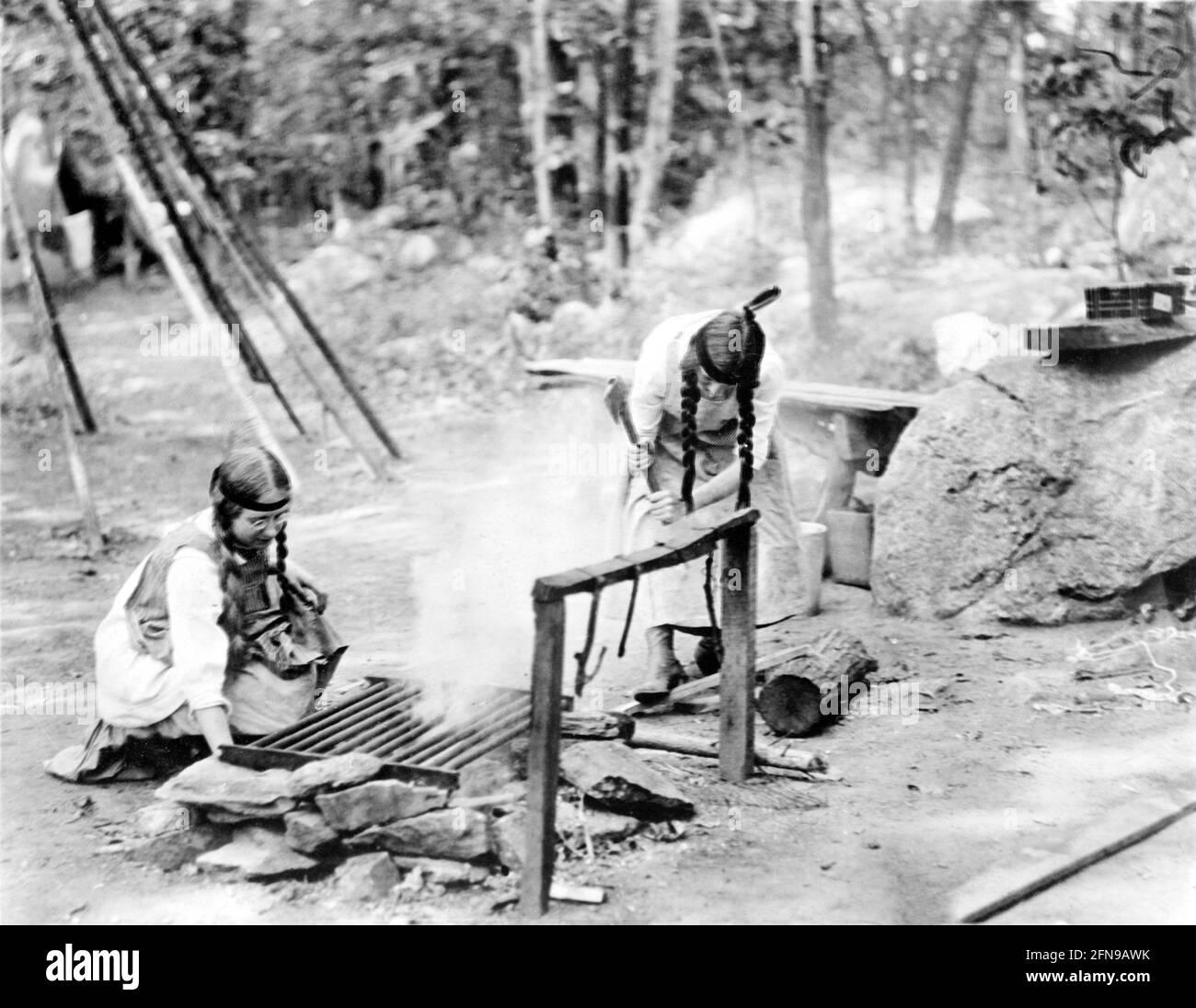 Scout ragazza. Due Scout ragazza che costruiscono un fuoco nel campo, c.. 1912 Foto Stock