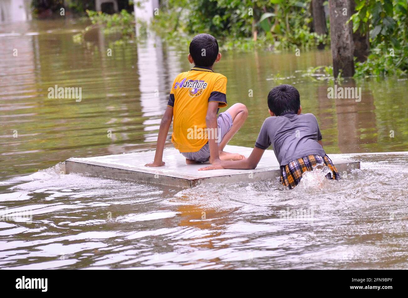 Colombo, Sri Lanka. 15 maggio 2021. I ragazzi sono visti su una strada allagata a Gampaha, Sri Lanka, 15 maggio 2021. Almeno quattro persone erano morte e più di 42,000 altre erano state colpite da giorni di forti venti e forti piogge che hanno abbattuto il paese a causa della formazione di un super ciclone nella baia del Bengala, Lo Sri Lanka Disaster Management Center (DMC) ha detto nel suo ultimo rapporto meteo Sabato. Credit: Gayan Sameera/Xinhua/Alamy Live News Foto Stock
