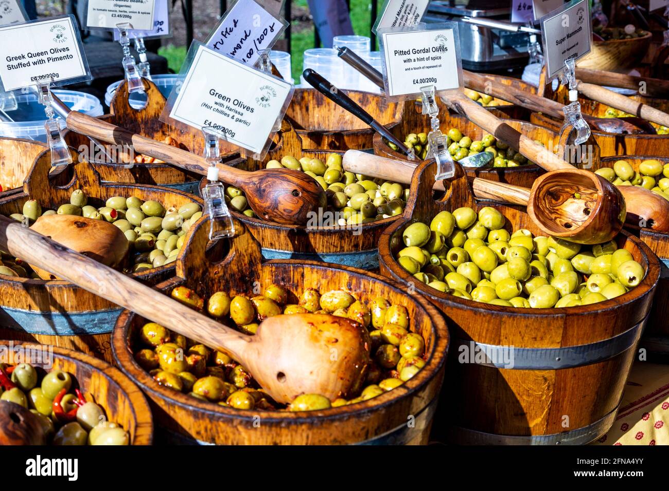 Fresh olive verdi in un secchio di legno e la siviera a un mercato agricolo (Parco Victoria Market, Londra, Regno Unito) Foto Stock