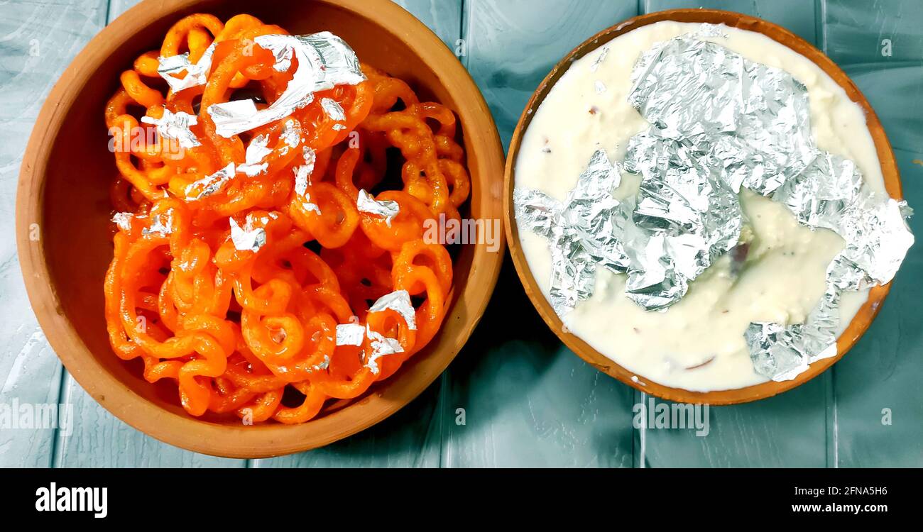 Kesari Jalebi/Jilbi con Rabbdi è una deliziosa ricetta indiana servita Come un Dessert in festival o matrimoni.fuoco selettivo Foto Stock