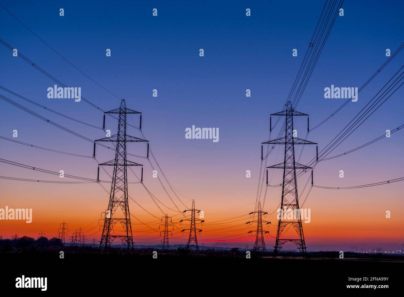 Linee elettriche al tramonto sulle paludi del Tamigi in basso Higham Kent Foto Stock