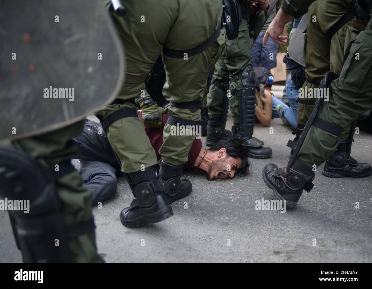 La polizia riota arresta un dimostratore pro-palestinese in mezzo a scontri con la polizia durante un raduno di solidarietà con i palestinesi, ha chiesto il conflitto in corso con Israele, fuori dall'ambasciata israeliana, ad Atene, Grecia, il 15 maggio 2021. Oggi in tutto il mondo si svolgono raduni per celebrare la Giornata di Nakba e il sostegno vocale ai palestinesi. Credit: Dimitris Aspiotis / Alamy Foto Stock