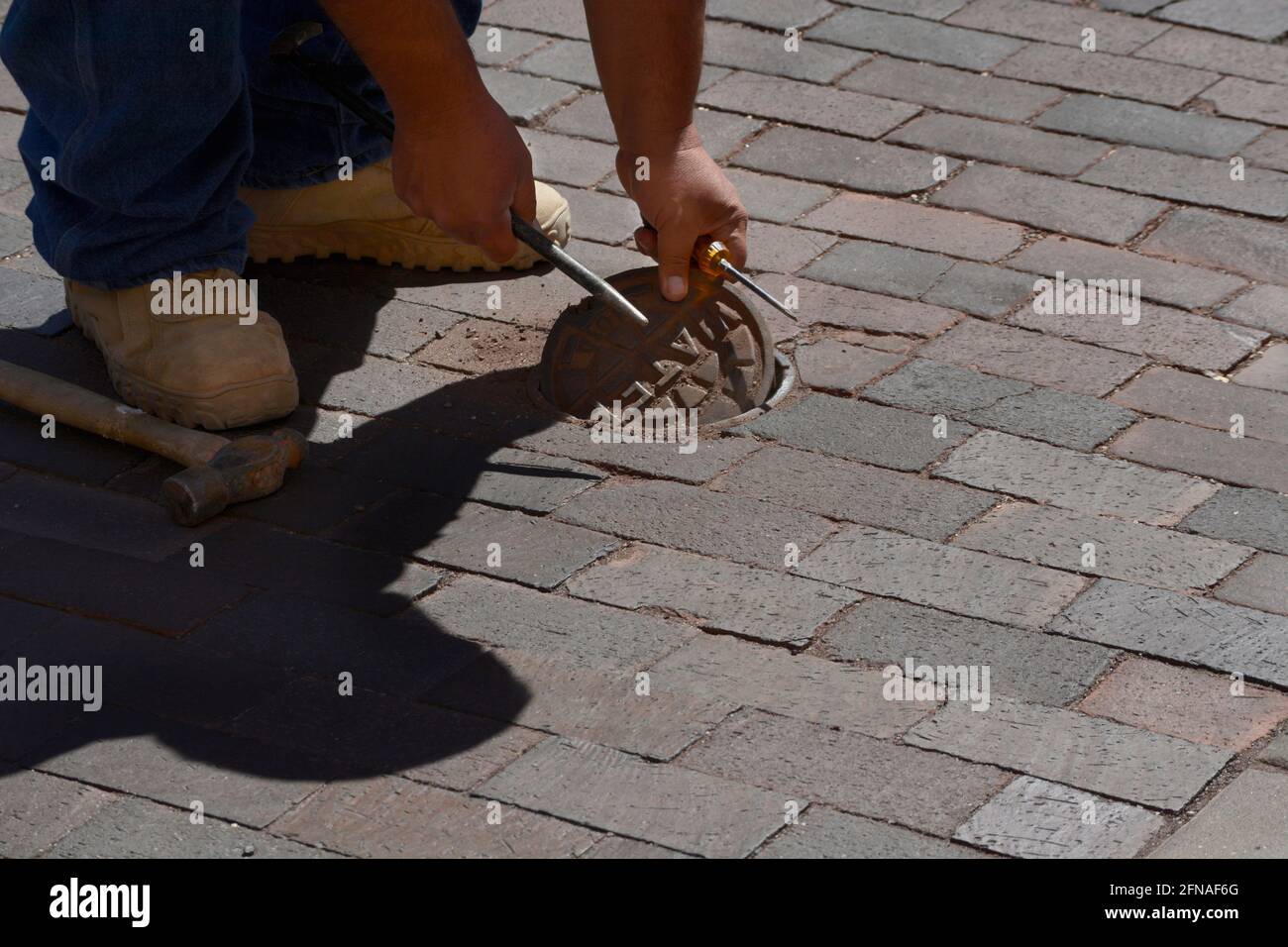 Un operaio della città controlla un portale di servizio di acqua a Santa Fe, New Mexico. Foto Stock