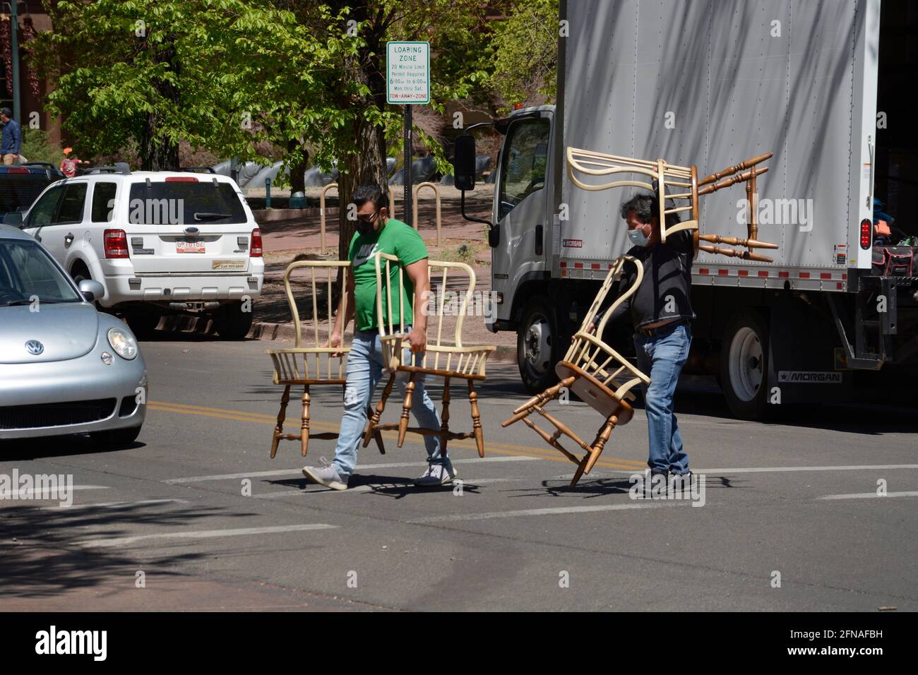 Due uomini consegnano sedie a un'azienda nel centro di Santa Fe, New Mexico. Foto Stock