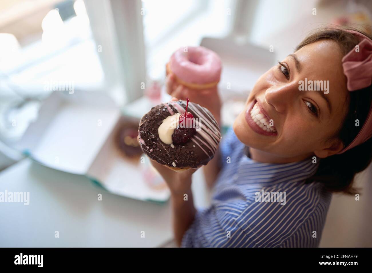 Il proprietario di piccola impresa è appassionato circa il suo prodotto/ciambelle invitante Foto Stock