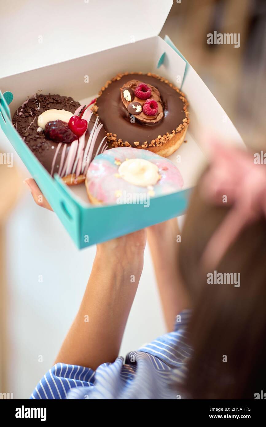 Primo piano di ciambelle fresche pronte per il trasporto alla pasticceria Foto Stock