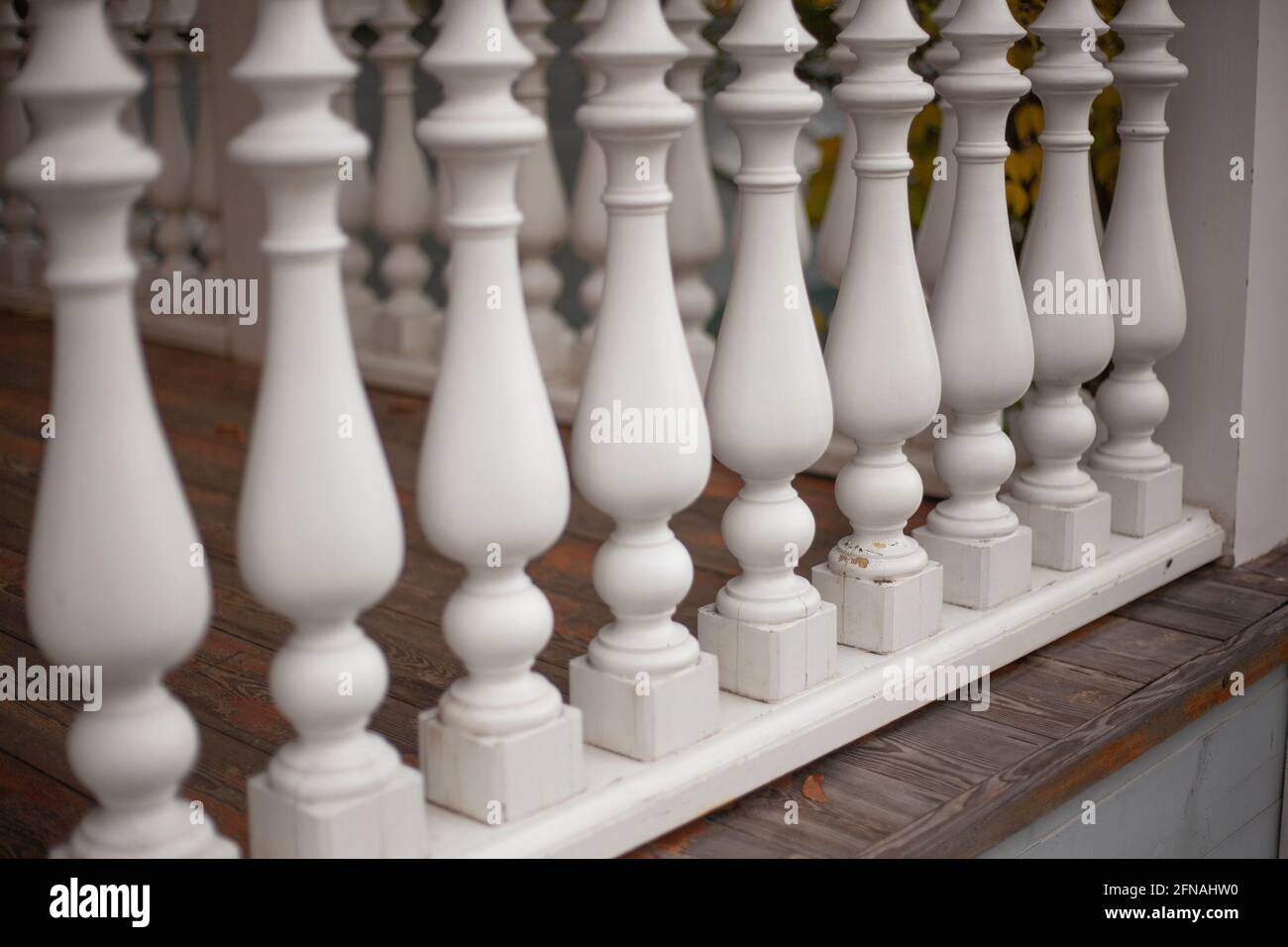 Elemento architettonico del baluster. Recinzione sulla veranda. Eleganti pavimenti in legno. Legno trattato in un cilindro. Una serie di deta casa ripetitiva Foto Stock