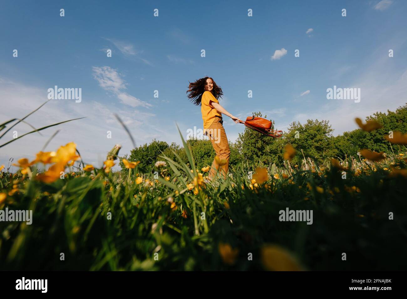 Ragazza felice con capelli che si flettono contro il cielo blu. Foto Stock