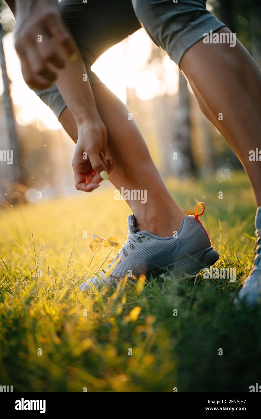 Gambe di un jogger in sneaker grigie. Foto Stock