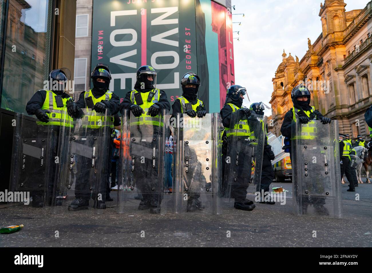 Glasgow, Scozia, Regno Unito. 15 maggio 202. I tifosi di calcio dei Rangers che celebrano la 55a vittoria della lega sono sgombrati da George Square dalla polizia in attrezzatura da rivolta il sabato sera. In scene molto violente la polizia è stata pelata con bottiglie e oggetti da un vicino cantiere mentre la polizia ha spinto i sostenitori nell'angolo sud-ovest della piazza. PIC; la polizia in equipaggiamento da sommossa attende l'ordine di entrare in George Square. Iain Masterton/Alamy Live News. Foto Stock