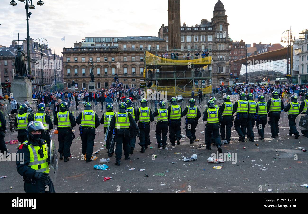 Glasgow, Scozia, Regno Unito. 15 maggio 202. I tifosi di calcio dei Rangers che celebrano la 55a vittoria della lega sono sgombrati da George Square dalla polizia in attrezzatura da rivolta il sabato sera. In scene molto violente la polizia è stata pelata con bottiglie e oggetti da un vicino cantiere mentre la polizia ha spinto i sostenitori nell'angolo sud-ovest della piazza. PIC; la polizia in marcia di rivolta entra in George Square. Iain Masterton/Alamy Live News. Foto Stock