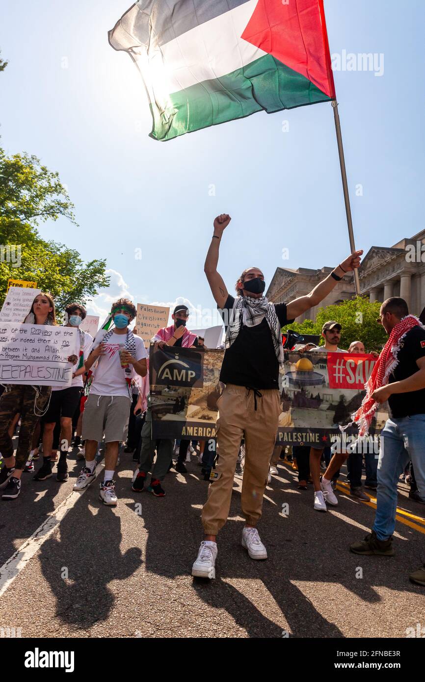 Washington, DC, Stati Uniti. 15 maggio 2021. Nella foto: Un protestante davanti alla marcia per la Palestina fa ondere una grande bandiera palestinese nel 73o anniversario del Nakba, sequestro israeliano della Palestina nel 1948. La data assume un significato maggiore quest'anno a seguito dell'invasione israeliana della moschea di al Aqua a Gerusalemme e degli attacchi aerei a Gaza. Credit: Alison Bailey/Alamy Live News Foto Stock