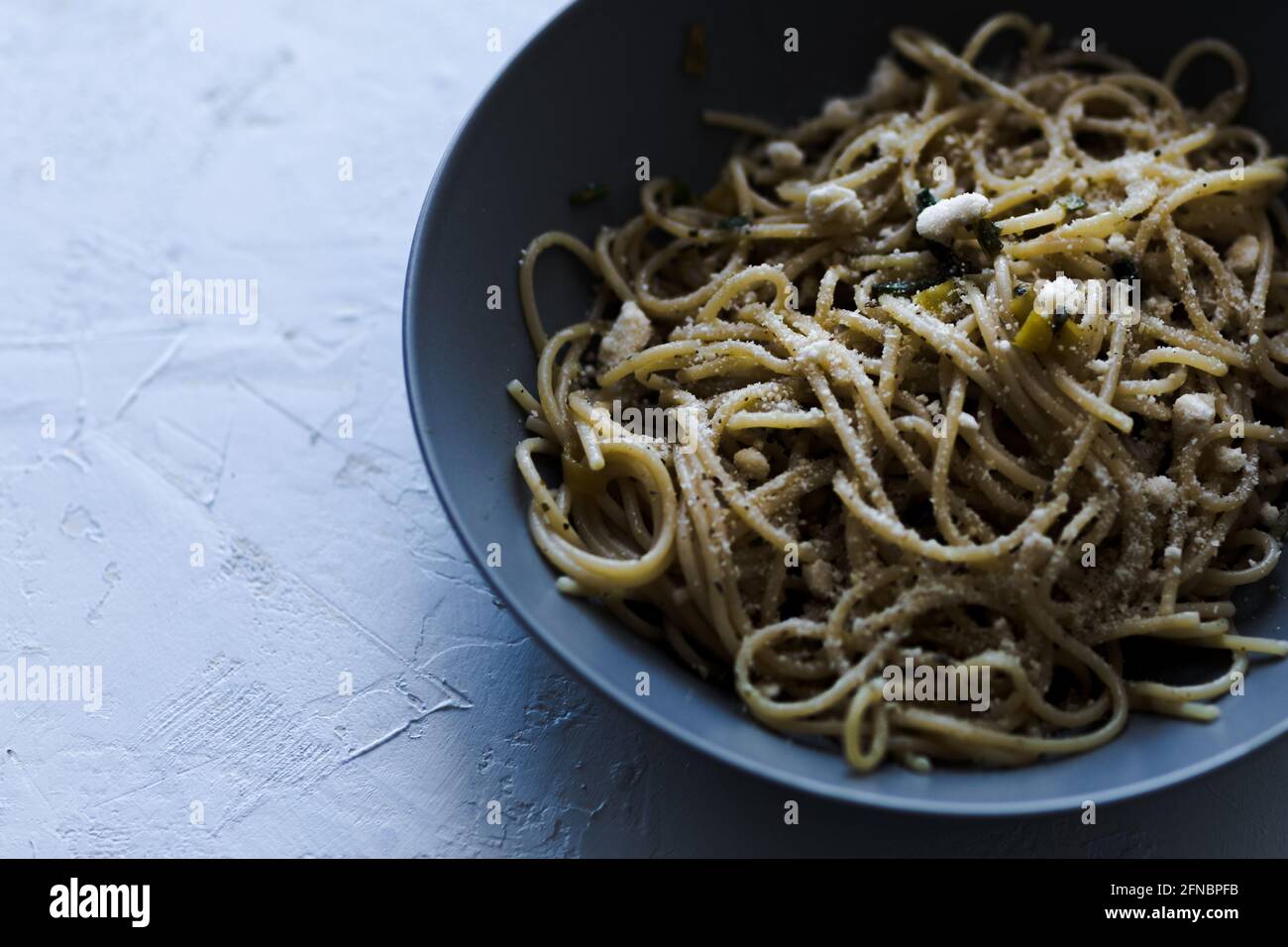 Un piatto di spaghetti su fondo blu. Foto Stock