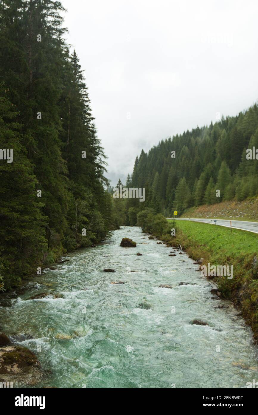 Un fiume blu che scorre attraverso l'Austria centrale in autunno in una giornata piovosa. Foto Stock