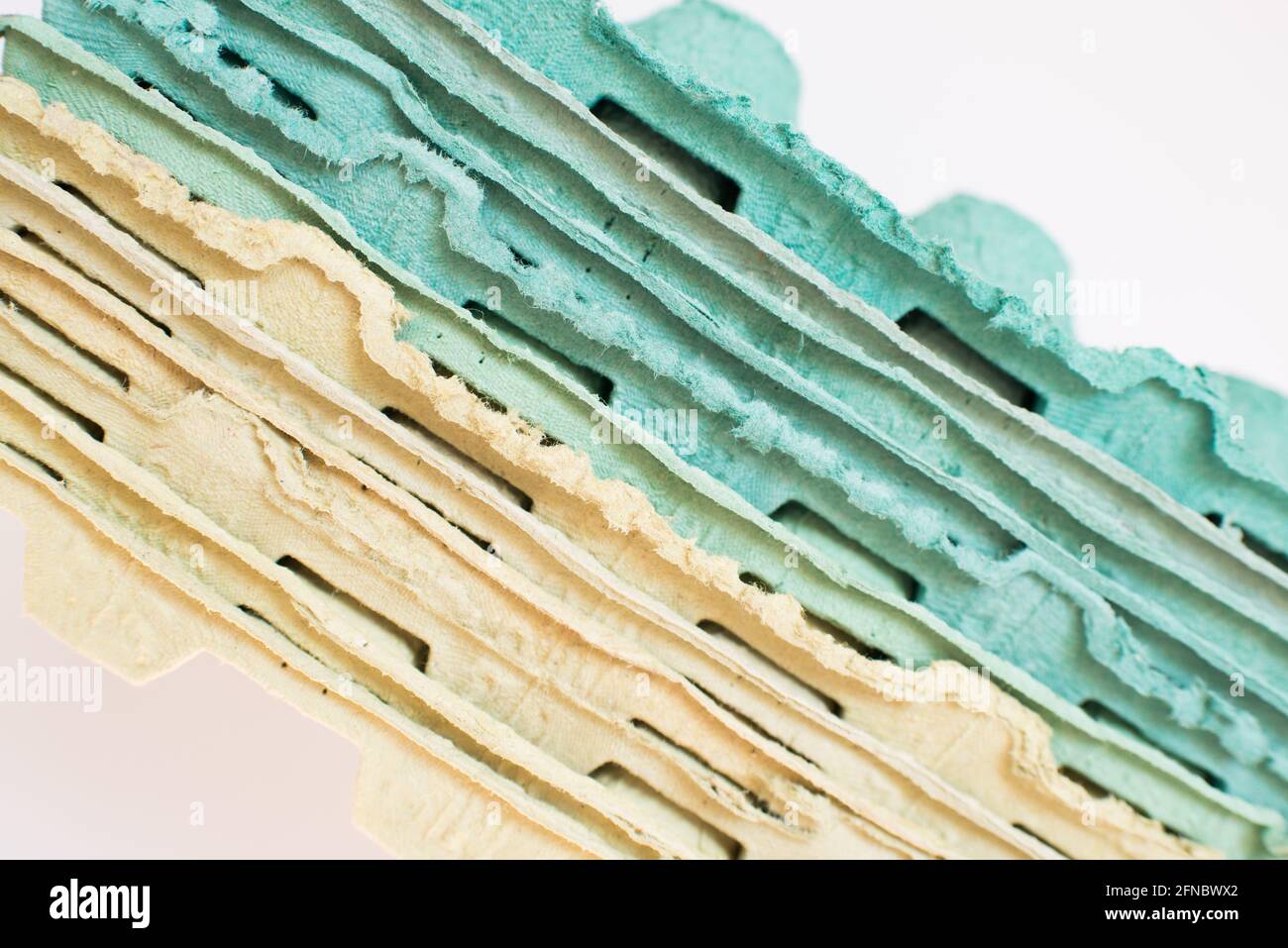 Texture. Pila di vassoi di cartone multicolore imballo per uova. Sfondo bianco Foto Stock